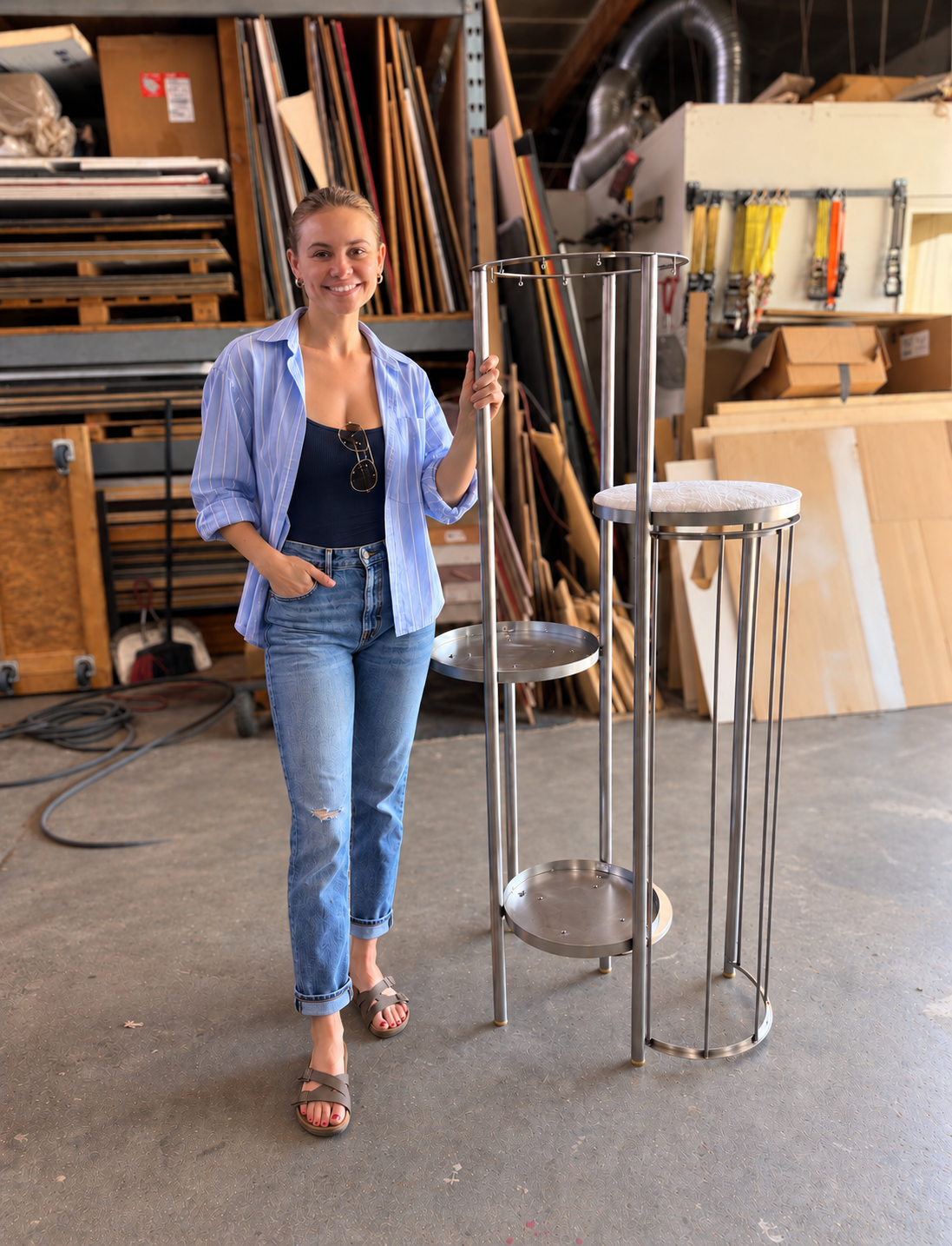 Lindsay standing beside the real metal tower prototype in the workshop